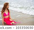 young girl sitting on the beach. by sea. tropical beach. summer style. 103350030