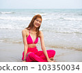 young girl sitting on the beach. by sea. tropical beach. summer style. 103350034
