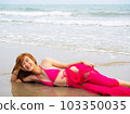young girl sitting on the beach. by sea. tropical beach. summer style. 103350035