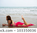 young girl sitting on the beach. by sea. tropical beach. summer style. 103350036