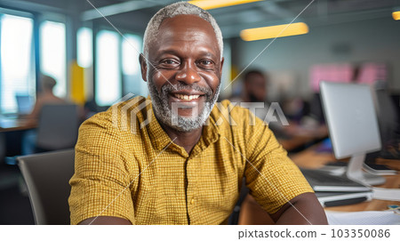 Portrait of a dark-skinned adult man with gray hair, who smiles and sits in the office at a laptop in a bright office, wearing a yellow shirt. AI generated. Portrait of a dark-skinned adult man with gray hair, who smiles and sits in the office at a laptop in a bright office, wearing a yellow shirt. AI generated. 103350086