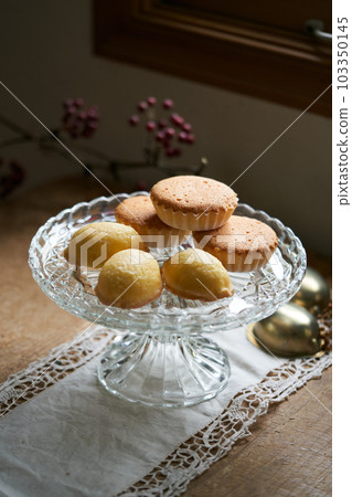Muffins and lemon cake served on a glass plate Muffins and lemon cake served on a glass plate 103350145