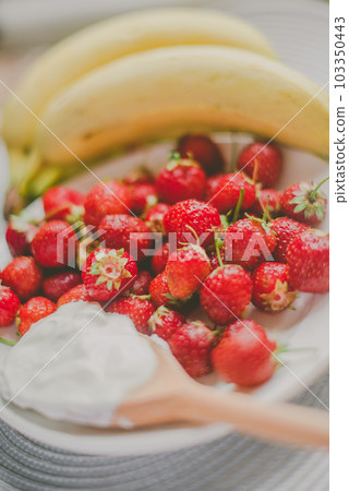 Bunch of bananas and strawberries. Photo toned style Instagram filters. Concept of healthy breakfast Bunch of bananas and strawberries. Photo toned style Instagram filters. Concept of healthy breakfast 103350443