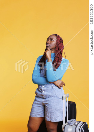 Young woman sightseeing on holiday trip in studio, looking at landmarks on scenic route. Excited person pointing at buildings architecture on citybreak, having fun on vacation. 103351590