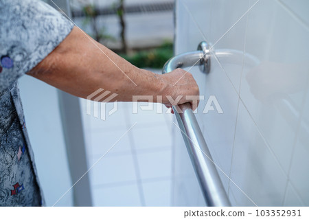 Asian elderly woman patient use toilet bathroom handle security in nursing hospital, healthy strong medical concept. Asian elderly woman patient use toilet bathroom handle security in nursing hospital, healthy strong medical concept. 103352931