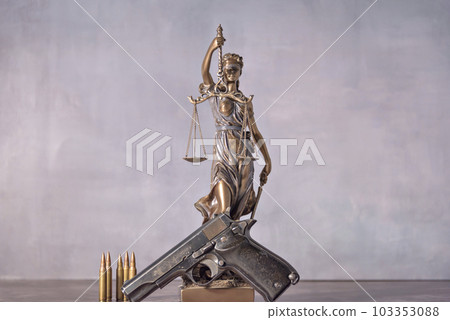 Gun in the foreground with the background is a representation of justice. Concept of use of arms and justice. Gun in the foreground with the background is a representation of justice. Concept of use of arms and justice. 103353088