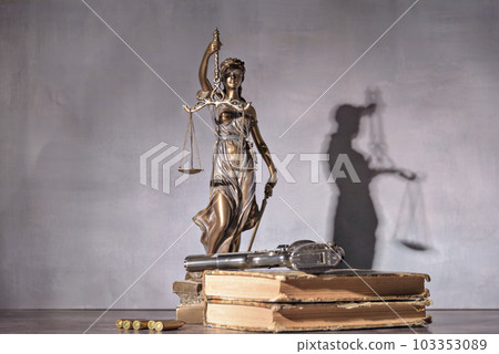 Gun in the foreground with the background is a representation of justice. Concept of use of arms and justice. Gun in the foreground with the background is a representation of justice. Concept of use of arms and justice. 103353089