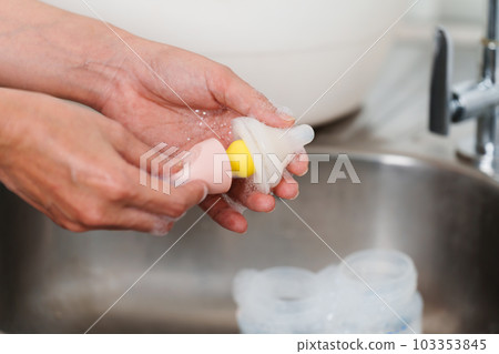 mother hand washing the baby nipple of milk bottle mother hand washing the baby nipple of milk bottle 103353845