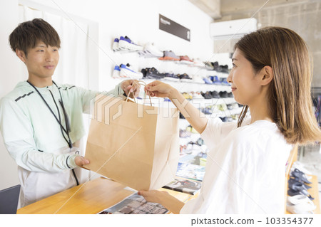 在收銀台購買商品後收到商品的年輕女性 103354377