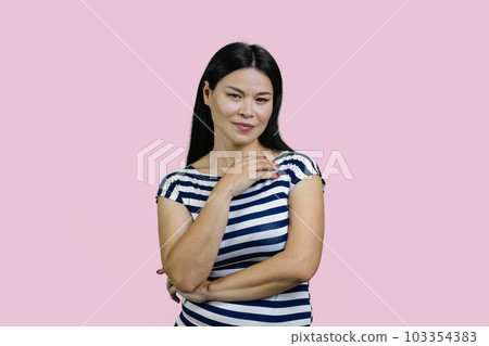 Portrait of korean asian woman in striped t-shirt. Isolated on pink background. Portrait of korean asian woman in striped t-shirt. Isolated on pink background. 103354383