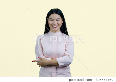 Portrait of happy cheerful asian woman with folded arms pointing to the right. Isolated on white background. Portrait of happy cheerful asian woman with folded arms pointing to the right. Isolated on white background. 103354569