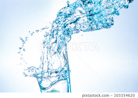 Drinking water splashing from the glass on white background Drinking water splashing from the glass on white background 103354620