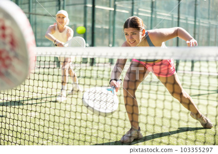 Young woman playing Padel Tennis in open-air tennis court 103355297