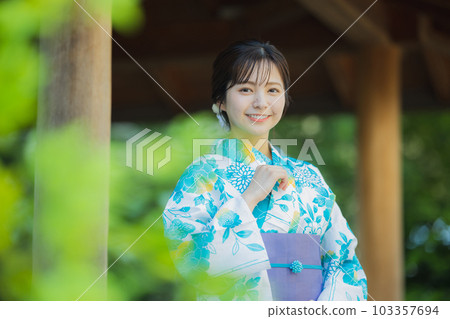 A woman in a yukata walking outdoors 103357694