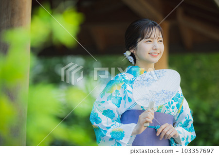 一個穿著浴衣的女人在戶外散步 103357697