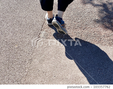 一個年輕人走路的鞋底和陰影 103357762