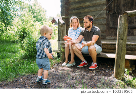 Mom, dad and little son spend time together in the summer outdoors 103359565