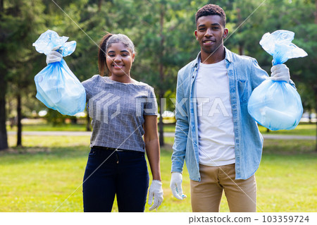 afro american volunteers collecting plastic trash at sunny day in summer park afro american volunteers collecting plastic trash at sunny day in summer park 103359724