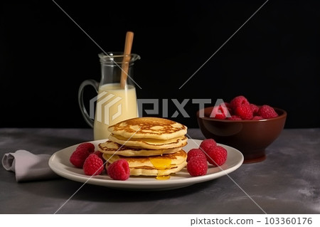 pancake con miele e lampone su un piatto accompagnato con il latte 103360176