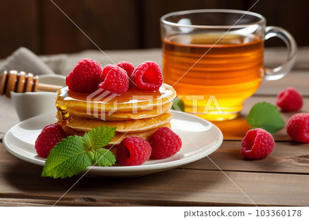 pancake spread with honey and raspberry on a plate 103360178