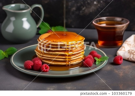 pancake spread with honey and raspberry on a plate 103360179