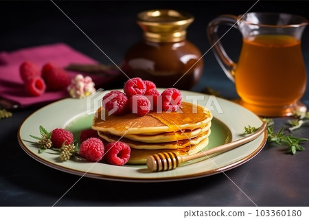 pancake spread with honey and raspberry on a white plate 103360180