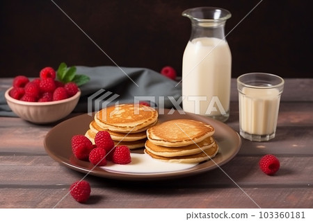 pancake spread with honey and raspberry on a plate accompanied with milk pancake spread with honey and raspberry on a plate accompanied with milk 103360181
