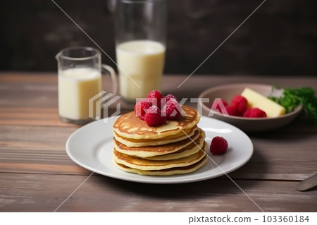 pancake spread with honey and raspberry on a plate accompanied with milk 103360184