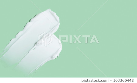 Beauty skincare cream texture swipe swatch. White beauty cream smear smudge isolated on green background Beauty skincare cream texture swipe swatch. White beauty cream smear smudge isolated on green background 103360448
