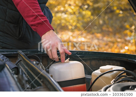 A man checks the level of technical fluids of the A man checks the level of technical fluids of the 103361500
