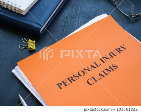A stack of papers with personal injury claims on the table. 103361822