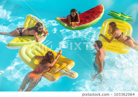 Friends in swimsuit in the pool getting a tan Friends in swimsuit in the pool getting a tan 103362064