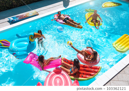 Friends in swimsuit in the pool getting a tan 103362121