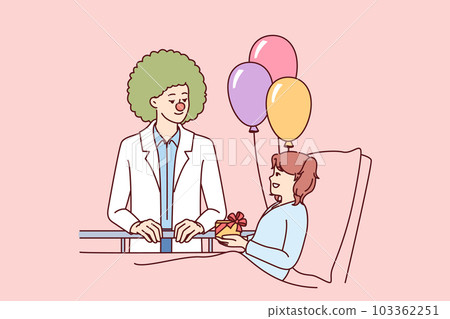 Clown doctor gives gift to child who is in hospital and needs support and positive emotions 103362251