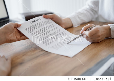 Businesswoman lawyer pointing into contract special points admitting something for colleague or client at the wooden desk in office. Business people teamwork and partnership, meeting concept Businesswoman lawyer pointing into contract special points admitting something for colleague or client at the wooden desk in office. Business people teamwork and partnership, meeting concept 103362341