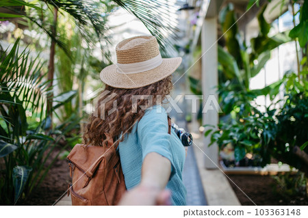 Rear view of young woman in botanical garden. Rear view of young woman in botanical garden. 103363148