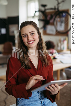 Portrait of young happy woman in office. Portrait of young happy woman in office. 103363201