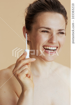woman with brow brush isolated on beige 103363210