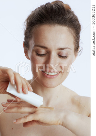 happy modern female with hand cream on white 103363212
