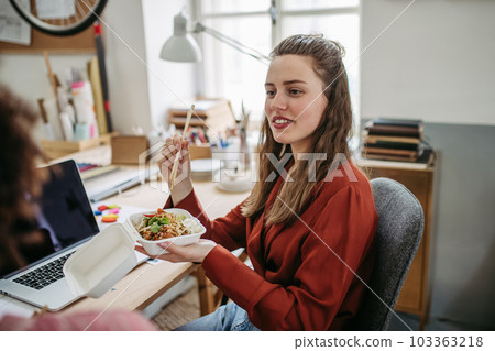 Young colleagues having lunch time in their office. 103363218