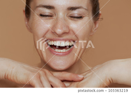 smiling woman with wet face washing 103363219