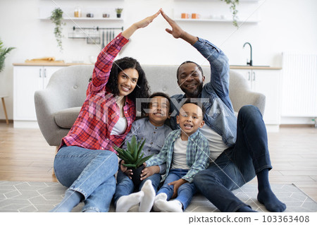 Adults making house by raised arms with kids inside 103363408