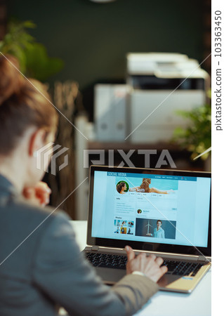 Seen from behind modern woman working on social media account 103363450