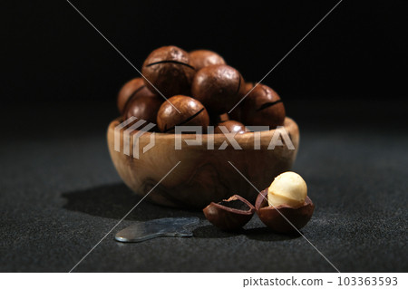 Macadamia nuts with a key on a black background. Macadamia nuts with a key on a black background. 103363593