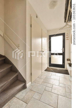 a hallway in a house with stairs leading up to the front door and an entryway on the right side a hallway in a house with stairs leading up to the front door and an entryway on the right side 103363631