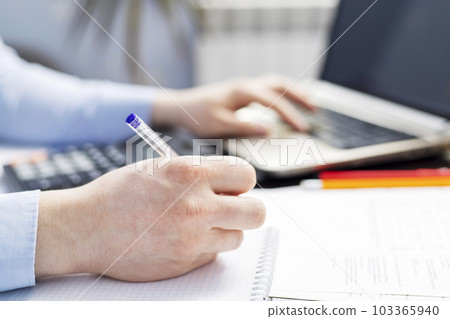 Businessman using calculator to calculate bills at the table in office 103365940