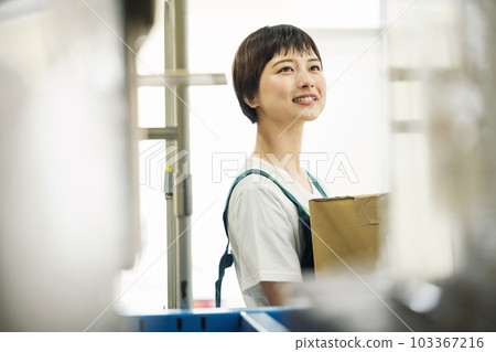 在倉庫里工作的年輕女子 103367216