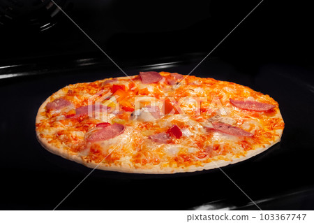 Baked homemade pizza in electric oven at home Baked homemade pizza in electric oven at home 103367747