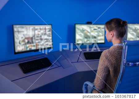 Woman security guard looking at modern cctv camera monitors Woman security guard looking at modern cctv camera monitors 103367817