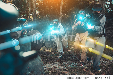 Teams playing paintball outdoors 103369351